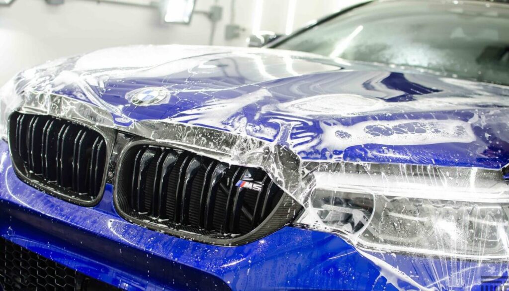 Men doing paint protection film for blue BMW Budget Auto Detailing Burlington ON